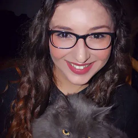 smiling woman holding gray cat