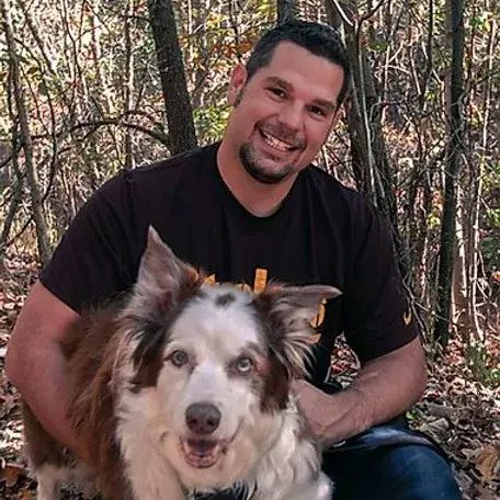smiling man with dog in the woods